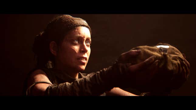 Senua holds an object as an offering.